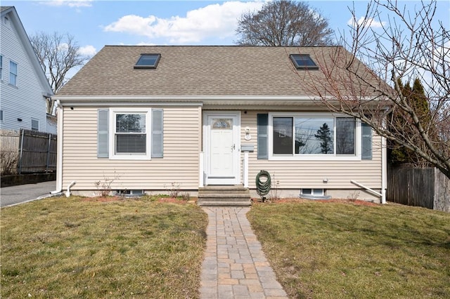 view of front of property featuring a shingled roof, fence, and a front lawn