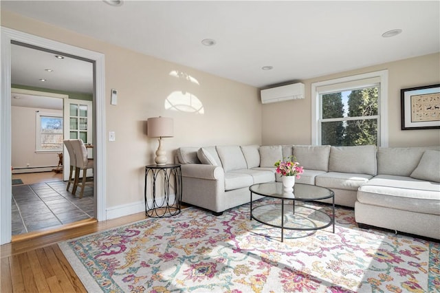 living area featuring recessed lighting, a baseboard heating unit, wood finished floors, baseboards, and a wall mounted AC