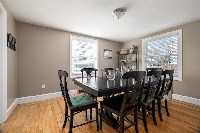 dining area with a healthy amount of sunlight, light wood-style flooring, and baseboards