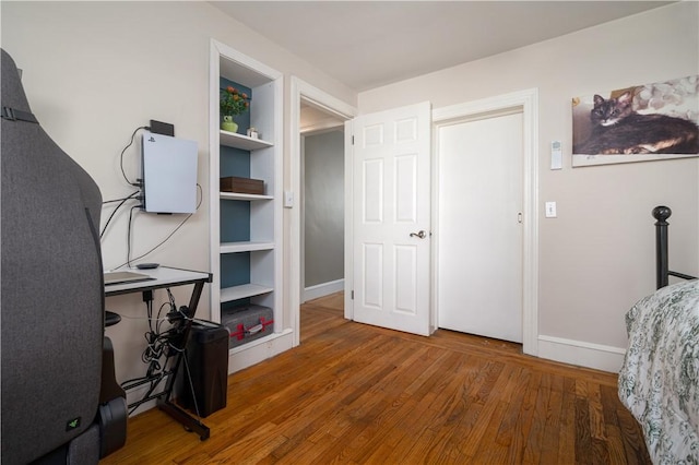 bedroom featuring baseboards and wood finished floors