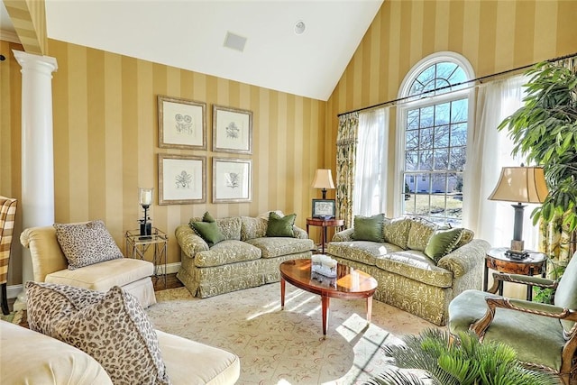 interior space featuring wallpapered walls, baseboards, high vaulted ceiling, and ornate columns