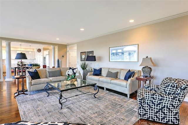 living area featuring recessed lighting, crown molding, ornate columns, and wood finished floors