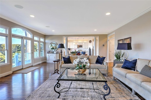 living area with ornamental molding, decorative columns, baseboards, and wood finished floors