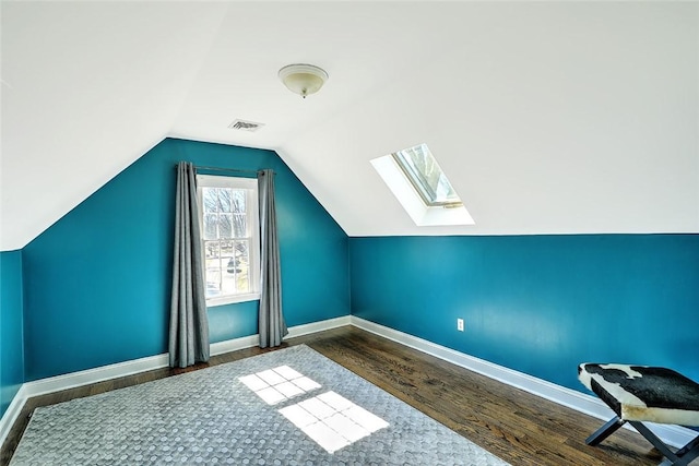 bonus room featuring baseboards, vaulted ceiling with skylight, visible vents, and wood finished floors