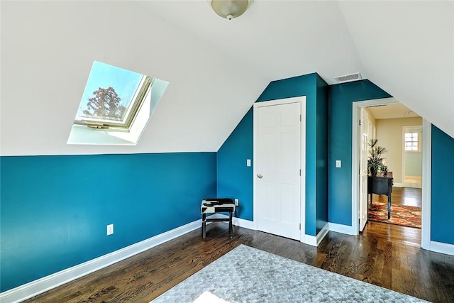 additional living space featuring lofted ceiling with skylight, wood finished floors, visible vents, and baseboards