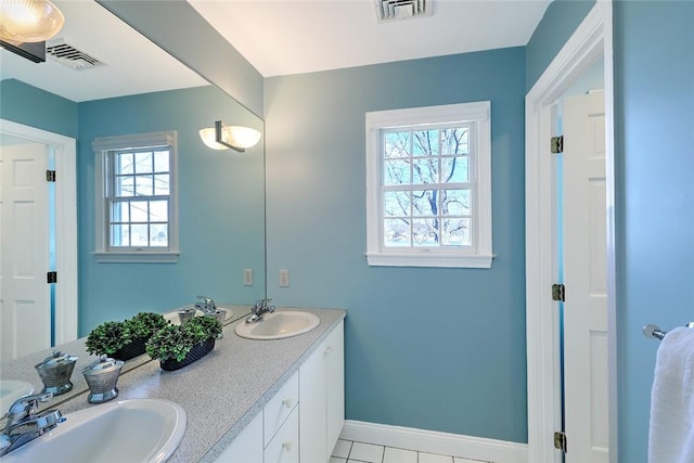 bathroom featuring baseboards, visible vents, and a sink