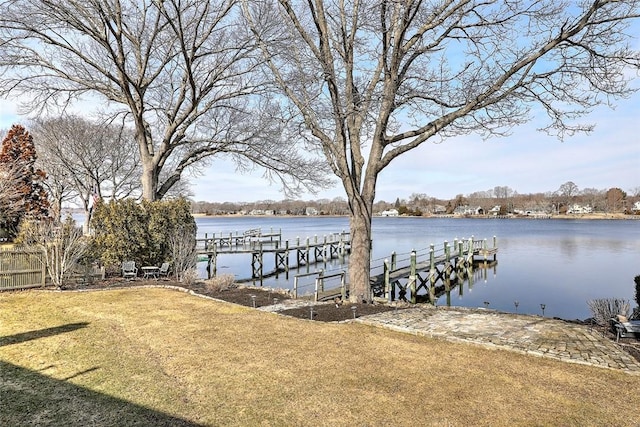 dock area with a yard and a water view