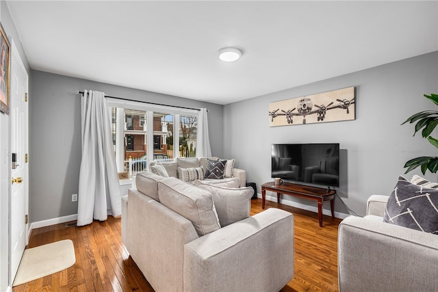 living room featuring baseboards and hardwood / wood-style floors