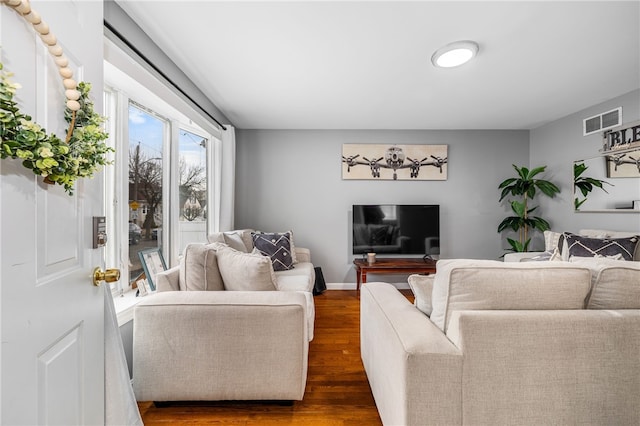 living room featuring visible vents, dark wood finished floors, and baseboards