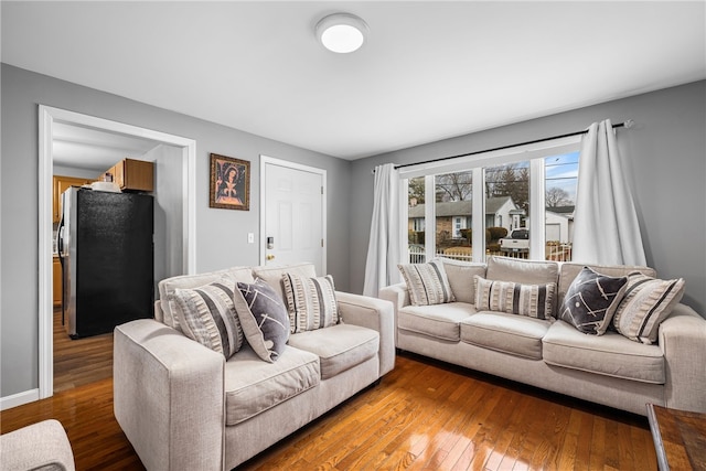 living area featuring baseboards and hardwood / wood-style flooring