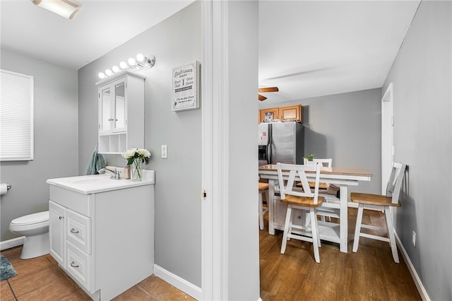 bathroom with toilet, baseboards, a ceiling fan, and vanity