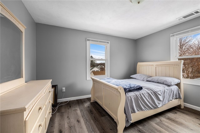 bedroom featuring dark wood-style flooring, visible vents, and baseboards