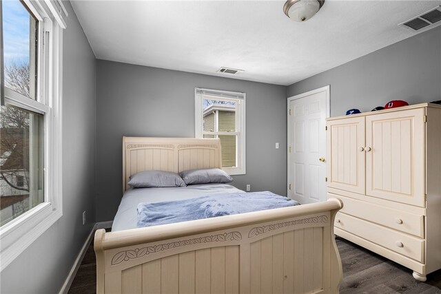 bedroom featuring dark wood-style floors, visible vents, and baseboards