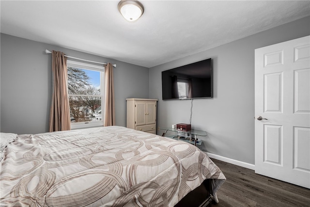 bedroom featuring dark wood-style flooring and baseboards