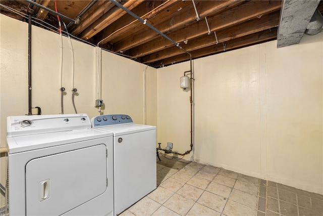 washroom featuring laundry area, light tile patterned floors, and separate washer and dryer