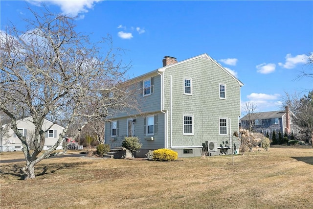 rear view of house featuring a yard and a chimney