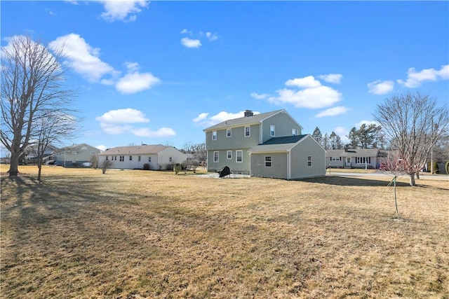 rear view of house with a yard and a chimney