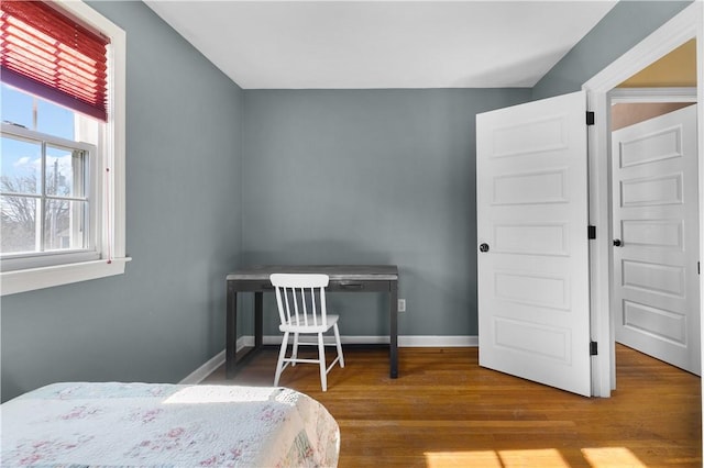 bedroom with wood finished floors and baseboards