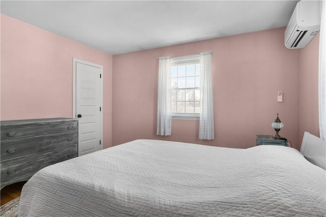 bedroom featuring wood finished floors and a wall mounted AC