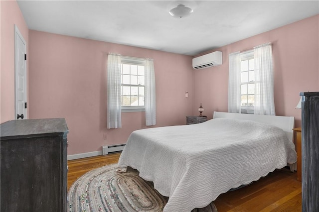 bedroom with light wood-style flooring, multiple windows, baseboard heating, and a wall mounted air conditioner