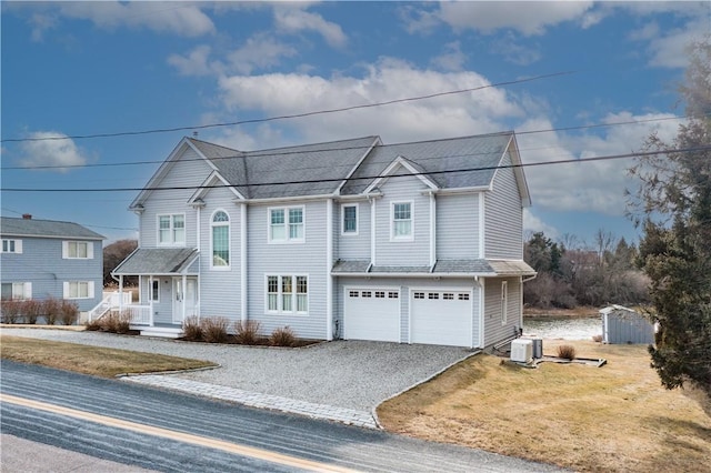 view of front of house featuring driveway, an attached garage, a storage unit, an outdoor structure, and a front yard