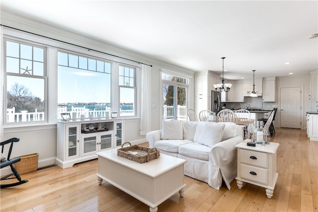 living room featuring a chandelier, recessed lighting, light wood-style flooring, and baseboards