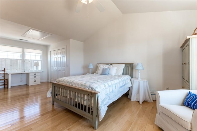 bedroom with lofted ceiling, visible vents, a closet, light wood finished floors, and attic access