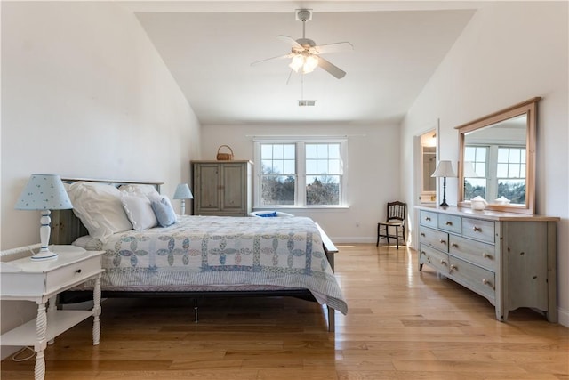 bedroom featuring lofted ceiling, visible vents, light wood-style flooring, and baseboards