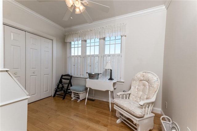 home office featuring a ceiling fan, light wood-style flooring, baseboards, and crown molding