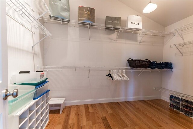 spacious closet with lofted ceiling and wood finished floors