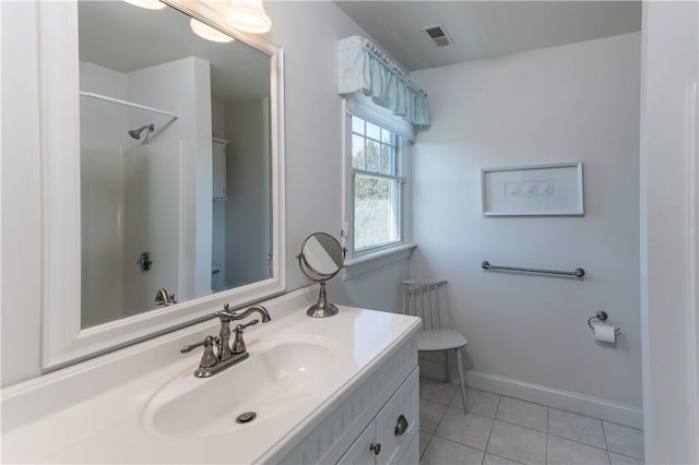 full bath featuring tile patterned floors, visible vents, vanity, baseboards, and walk in shower