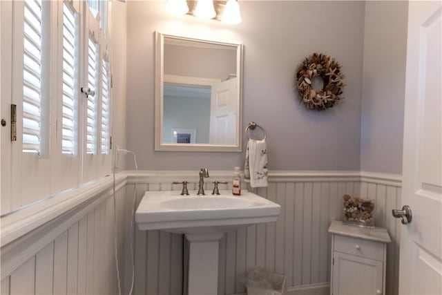 bathroom featuring a wainscoted wall and a sink