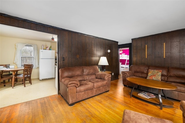 living area with wood walls and light wood finished floors