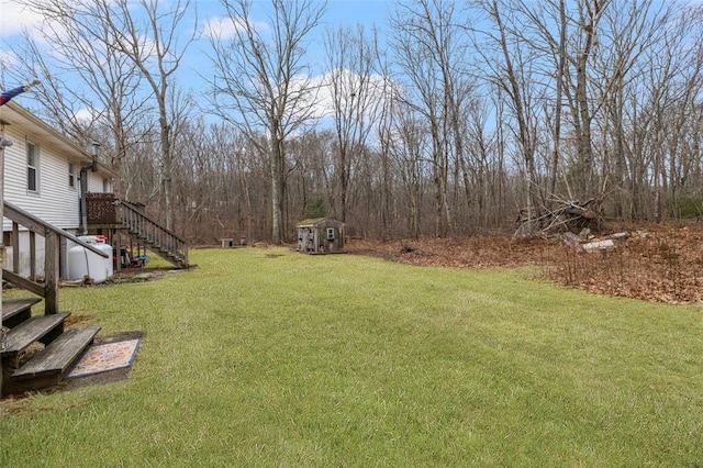 view of yard with an outdoor structure, stairway, and a shed