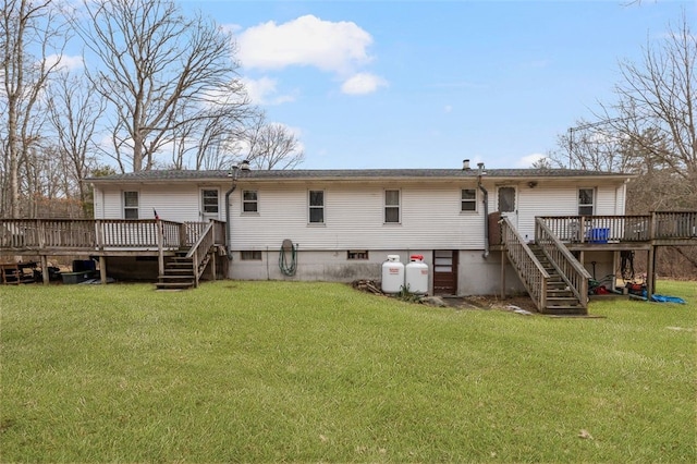 back of property with stairs, a deck, and a lawn