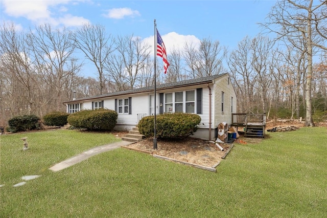 single story home featuring a front yard and a deck