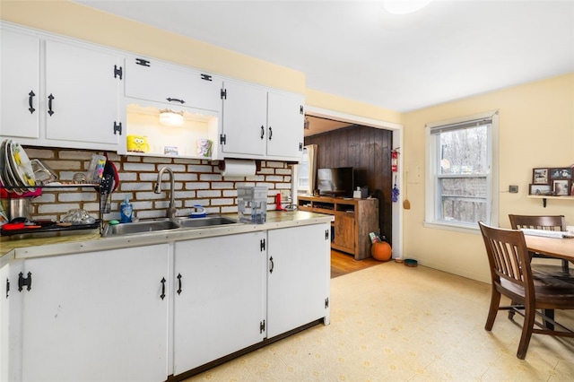 kitchen featuring light countertops, light floors, a sink, and white cabinetry