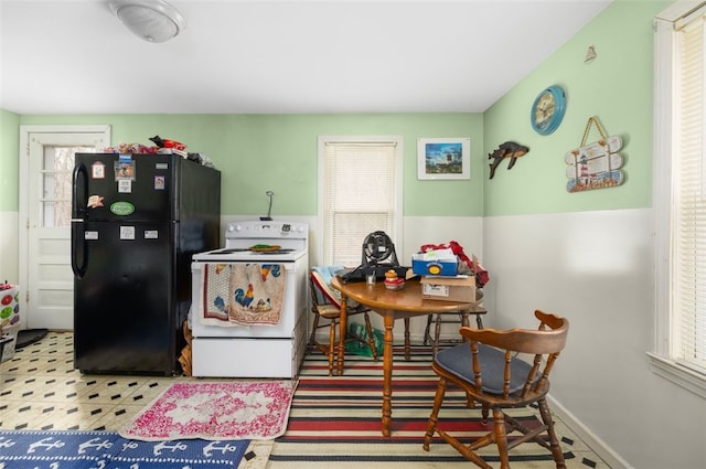 kitchen featuring tile patterned floors, white range with electric cooktop, and freestanding refrigerator