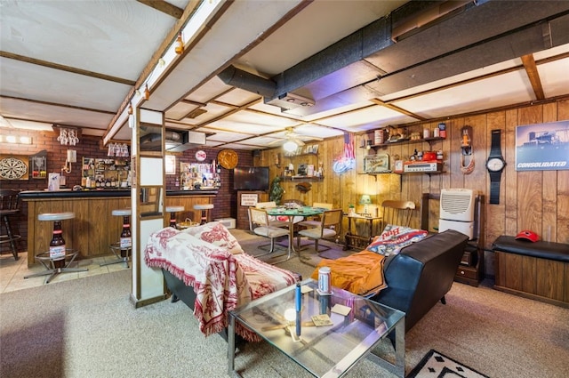 living area with a bar, carpet, and wooden walls