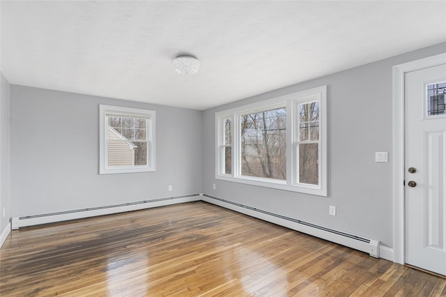 empty room featuring a baseboard heating unit, a baseboard radiator, and hardwood / wood-style flooring