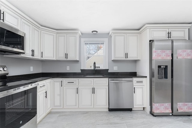 kitchen featuring stainless steel appliances, dark countertops, and a sink