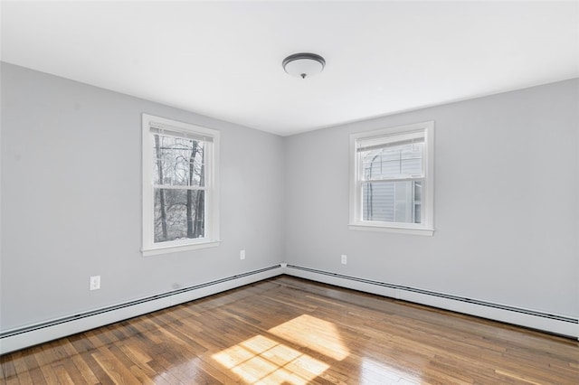 empty room with baseboard heating and hardwood / wood-style flooring