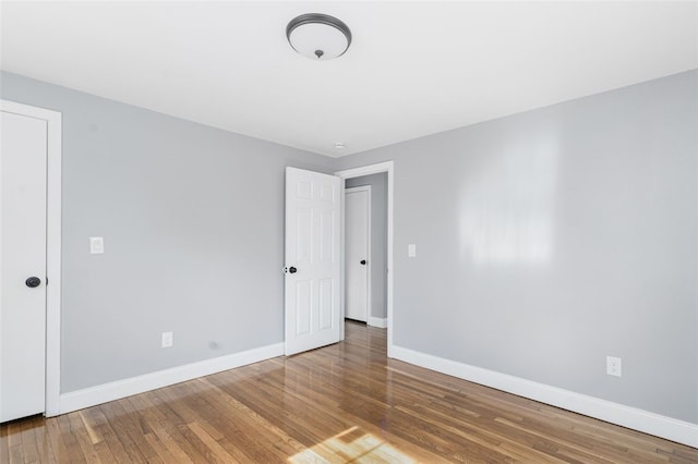 empty room with baseboards and wood finished floors