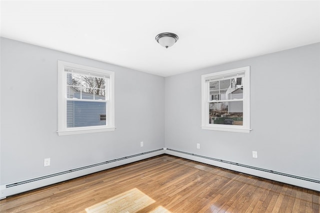 spare room featuring wood-type flooring and baseboard heating