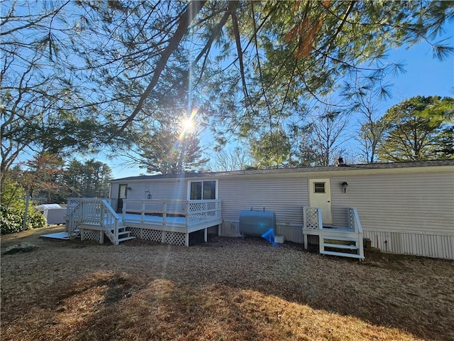 back of house with heating fuel and a deck