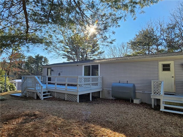 back of property with a wooden deck and heating fuel