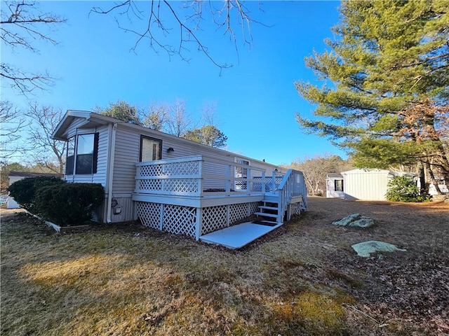 rear view of house featuring a yard and a wooden deck