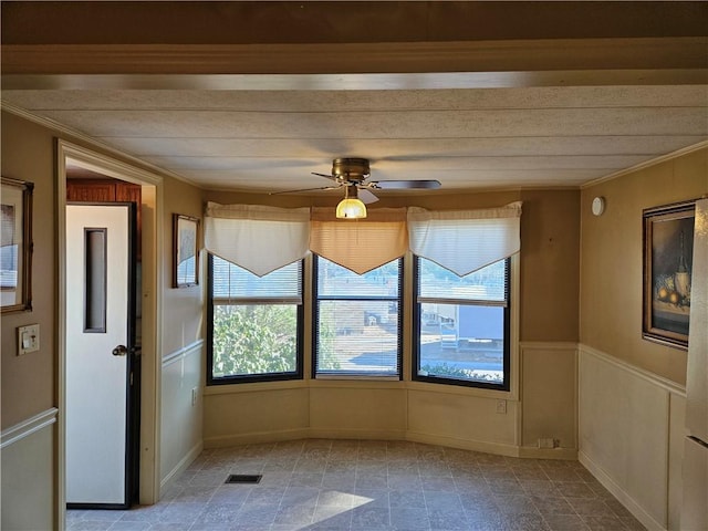 unfurnished room featuring ceiling fan, visible vents, and crown molding