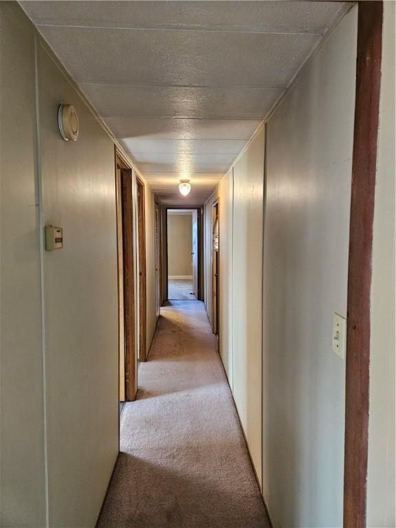 hall with light colored carpet