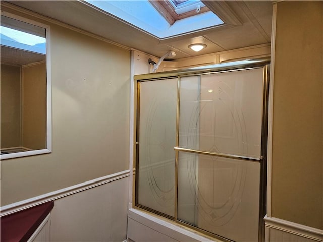 bathroom with a skylight and a shower with shower door